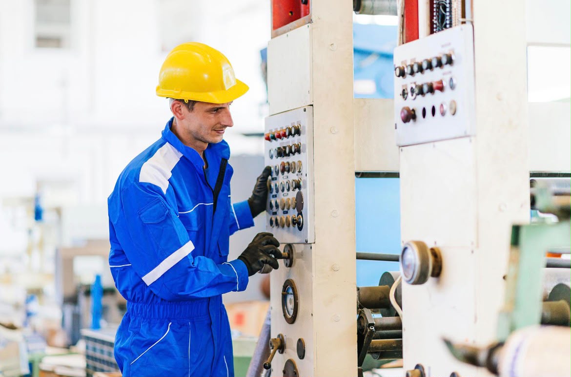 Technician operating industrial production machinery